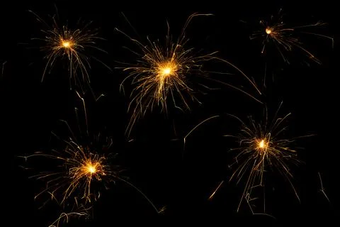 Sparkling burning sparkler on a black background. Stock Photos