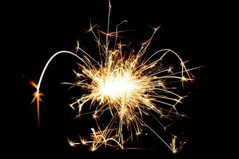 Sparkling burning sparkler on a black background. Stock Photos