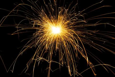 Sparkling burning sparkler on a black background. Stock Photos