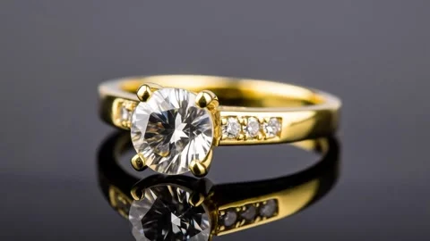 Sparkling Diamond Ring: Elegant Gold Jewelry on Reflective Surface Stock Footage 333410772