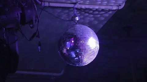 Sparkling disco ball spins with flashing LED lights, music band performance Stock Footage