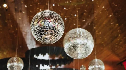 Sparkling disco balls hanging from a bright wooden ceiling, beautifully Stock Footage 324677785