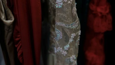 Sparkling dresses hang on rack in fitting room indoors Stock Footage 74861818