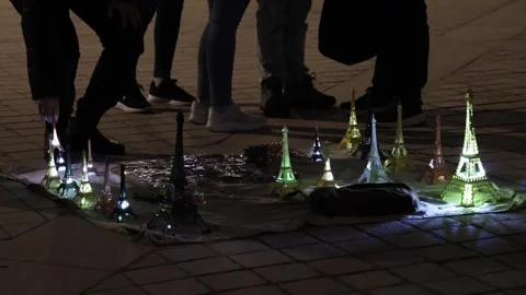 Sparkling Eiffel Tower models for sale by local street sellers. Stock Footage 330889323