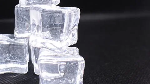 Sparkling ice cubes forming a small pyramid on a dark background, symbolizi.. Stock Photos