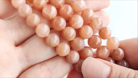 Sparkling orange gemstone beads arranged neatly on thin threads Stock Footage 345139721