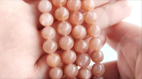 Sparkling orange gemstone beads arranged neatly on thin threads Stock Footage 345139724