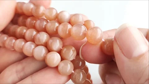 Sparkling orange gemstone beads arranged neatly on thin threads Stock Footage 345139725