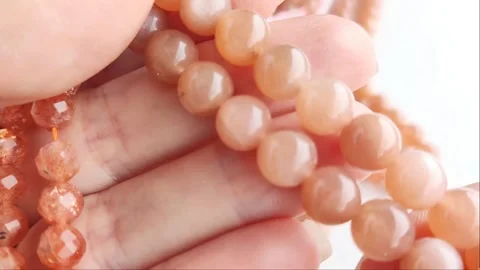Sparkling orange gemstone beads arranged neatly on thin threads Stock Footage 345139749
