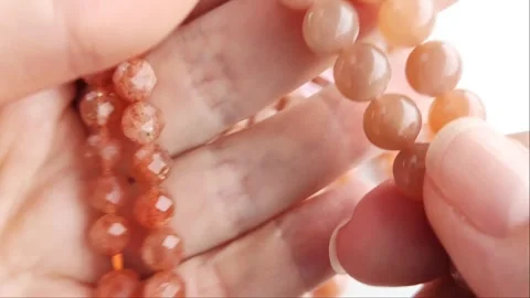 Sparkling orange gemstone beads arranged neatly on thin threads Stock Footage 345139756