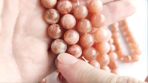 Sparkling orange gemstone beads arranged neatly on thin threads Stock Footage 345139762