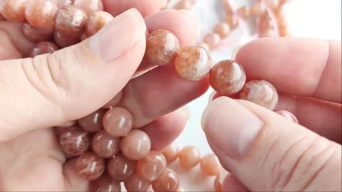 Sparkling orange gemstone beads arranged neatly on thin threads Stock Footage 345139767