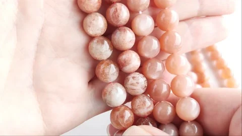 Sparkling orange gemstone beads arranged neatly on thin threads Stock Footage 345139768