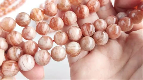 Sparkling orange gemstone beads arranged neatly on thin threads Stock Footage 345139775