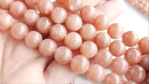 Sparkling orange gemstone beads arranged neatly on thin threads Stock Footage 345139779