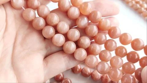 Sparkling orange gemstone beads arranged neatly on thin threads Stock Footage 345139780