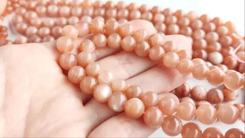 Sparkling orange gemstone beads arranged neatly on thin threads Stock Footage 345139786