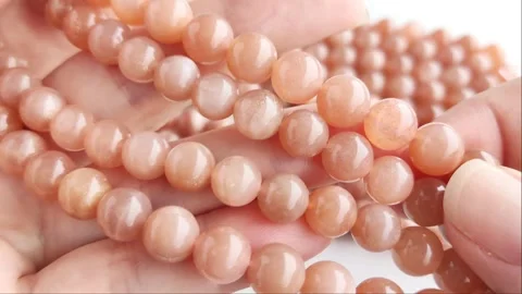 Sparkling orange gemstone beads arranged neatly on thin threads Stock Footage 345139788