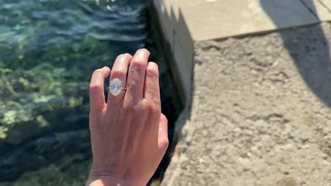 Sparkling oval diamond engagement ring by the turquoise water Croatia lifestyle Stock Footage 319406907
