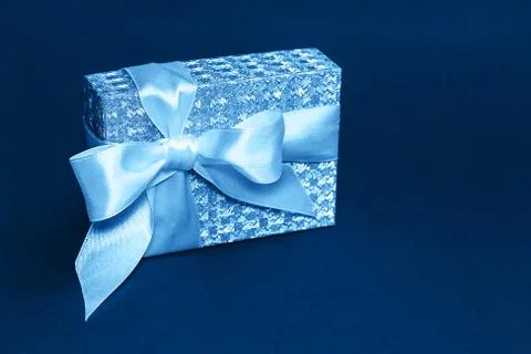 Sparkling present box with a silk bow in trendy blue color. Mockup for your Stock Photos