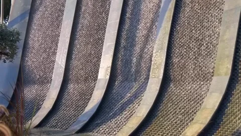 Sparkling in the rays of the sun, the waterfall flows down a vertical wall  Stock Footage 323943932