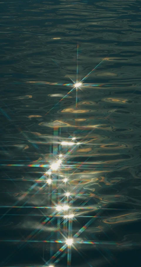 Sparkling reflections move across dark water. Video stock 345724021