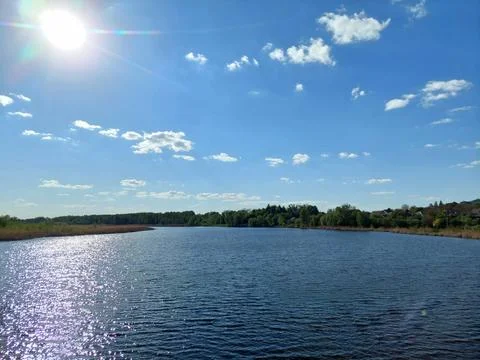 Sparkling sun reflections on a wide river under blue sky Fotos de archivo