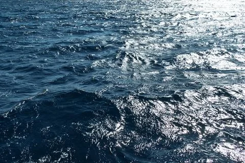 Sparkling sunlight on deep blue ocean waves Stock Photos
