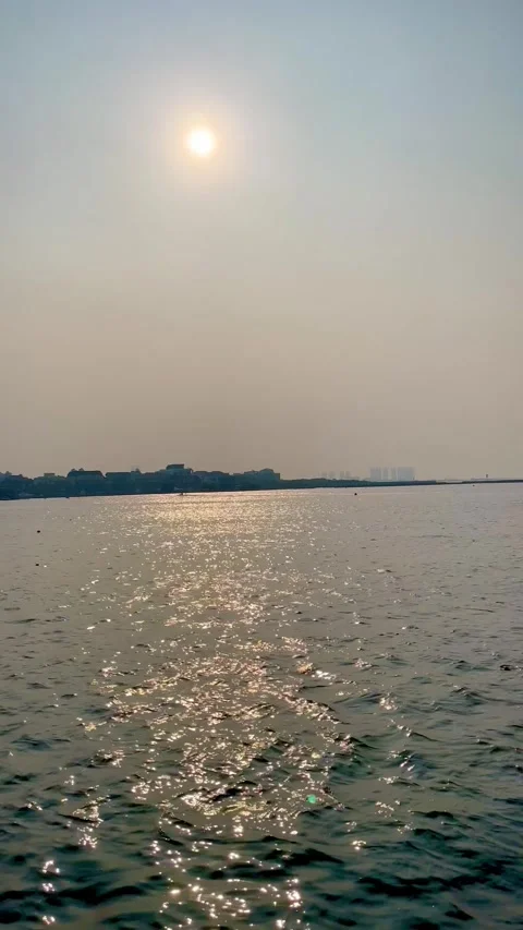Sparkling sunlight reflection on calm sea water surface with distant coastline Stock Footage 343140803