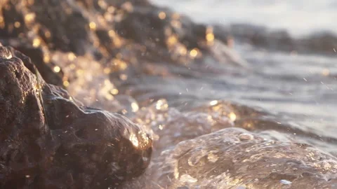 Sparkling sunlight reflects brightly across wet rocks on ocean shore. Stock Footage 337414284