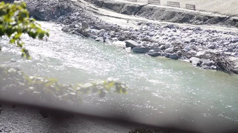 Sparkling water flows through a rocky riverbed in bright daylight Stock Footage 335270773