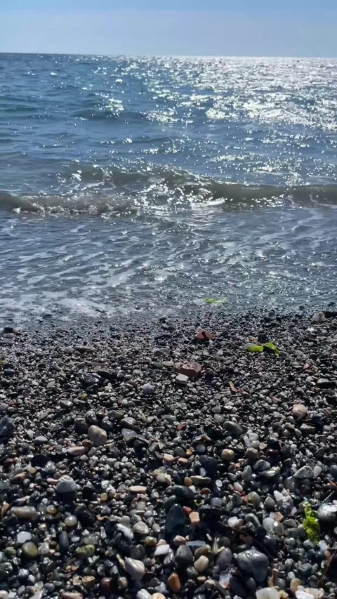 Sparkling Waves Gently Washing Over Pebble Beach on a Sunny Day Stock Footage 310210675