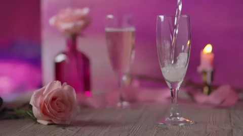 Sparkling white wine being poured into a glass on a wooden table Video stock 334337818