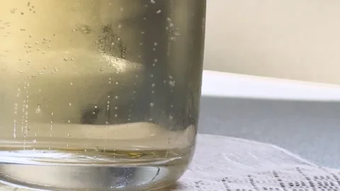 Sparkling white wine or soda with carbonated bubbles rising in glass cup cl.. Stock Footage 333621647
