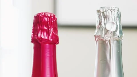 Sparkling wine bottle foil necks in red and silver close up Stock Footage 340254403