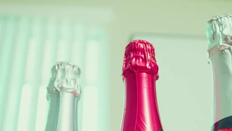 Sparkling wine bottle foil necks in red and silver close up Stock Footage 340283586