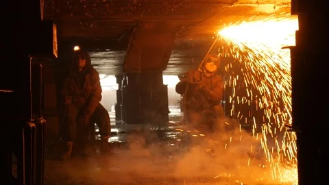 Sparks and smoke from the work of two welders in dry dock Stock Footage 87505664