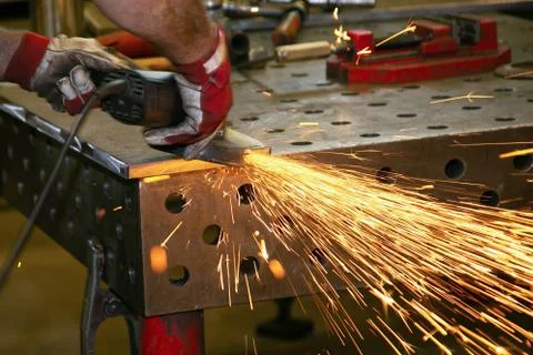 Sparks from a angle grinder in the hands of a worker Stock Photos