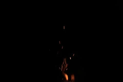 Sparks from campfire over dark background in the night Stock Photos