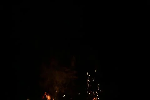 Sparks from campfire over dark background in the night Stock Photos