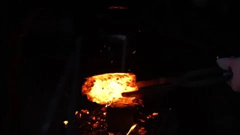 Sparks explode from hammered glowing metal with each impact Stock Footage 317137955