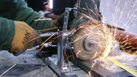 Sparks fly from angle grinder as worker cuts metal beam Video stock 193910641