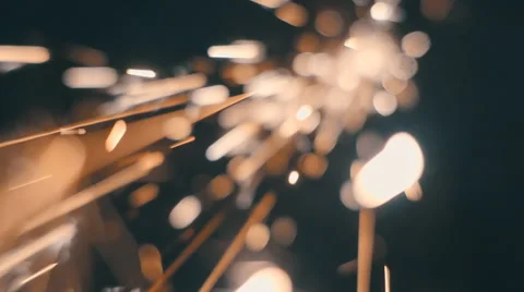 Sparks fly directly into the camera against a black background. Slow mo Video stock 64879030