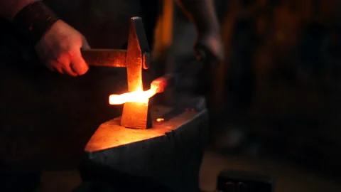Sparks fly out from under the blacksmith's hammer Stockbeeldmateriaal 99740710