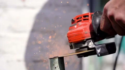 Sparks fly from under grinder of rustling metal in the open space. Side view Stock Footage 192275794