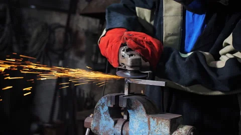 Sparks fly from under the grinding machine grinding the angular profile clamped Stock Footage 209606302