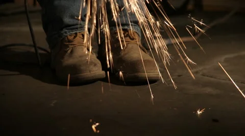 Sparks flying all around work boots. Stock Footage 46502195