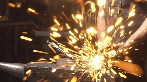 Sparks flying at the camera. A man working angular grinding machine. Blacksmith Stock Footage 77165084