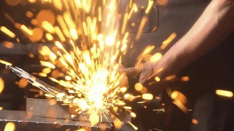 Sparks flying at the camera. Man working angular grinding machine. Slow motion Stock Footage 77385064