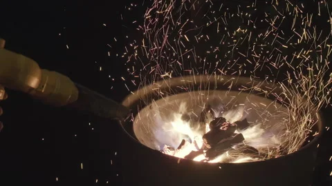 Sparks flying dramatically from the firepit in a dark setting Stock Footage 280688419